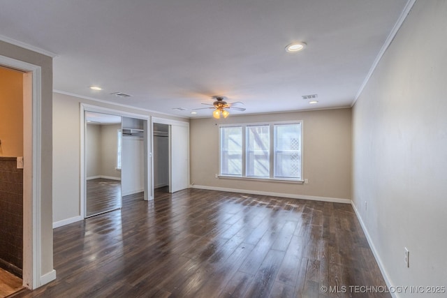 unfurnished bedroom featuring dark wood-style floors, visible vents, crown molding, and baseboards