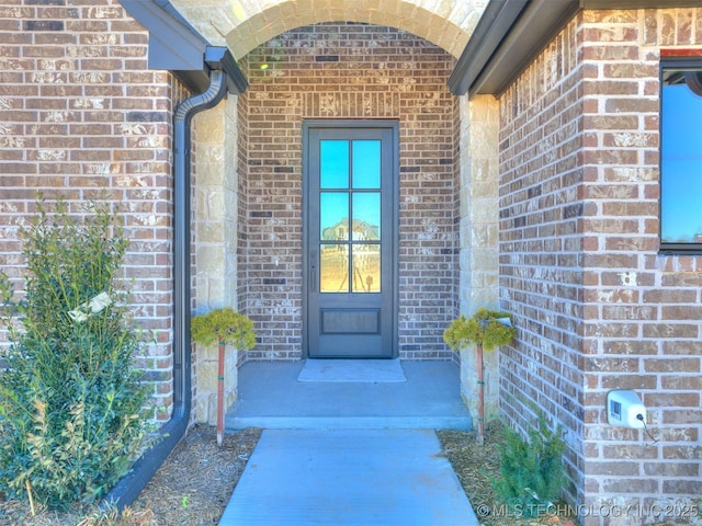 doorway to property featuring brick siding