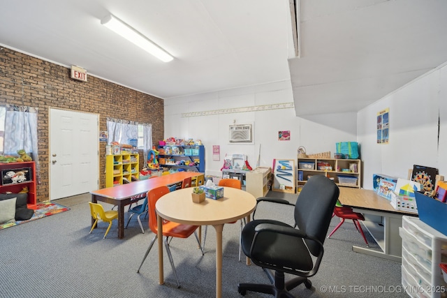 rec room featuring brick wall, a wall mounted AC, and carpet