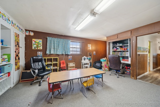 carpeted office featuring wooden walls