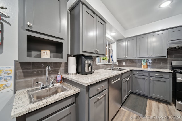 kitchen featuring appliances with stainless steel finishes, a sink, and gray cabinetry