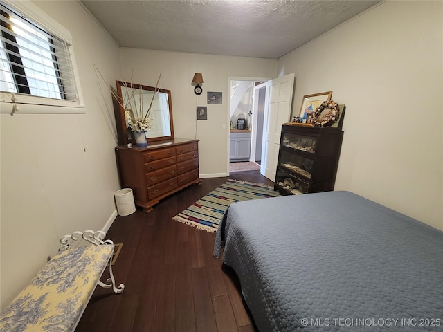 bedroom with a textured ceiling, baseboards, and wood finished floors