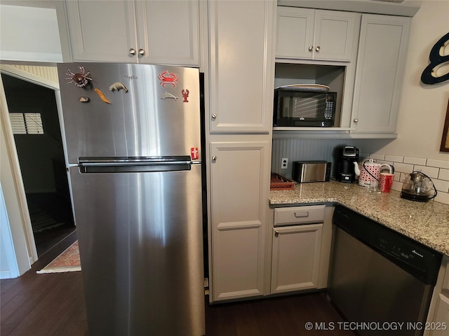 kitchen with stainless steel appliances, dark wood-type flooring, white cabinets, and light stone countertops