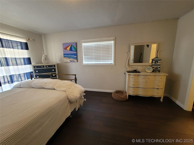 bedroom featuring wood finished floors and baseboards