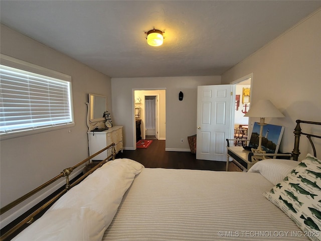 bedroom with dark wood-type flooring and baseboards