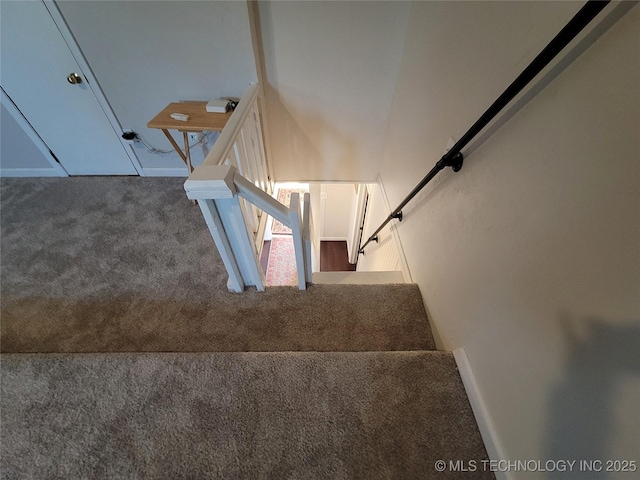 stairs featuring carpet and baseboards