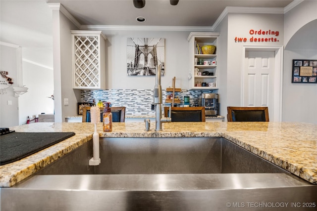 kitchen with crown molding, a sink, and decorative backsplash