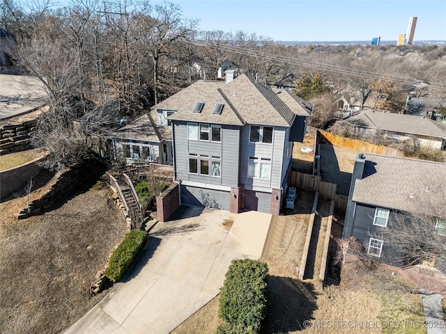 view of front of property featuring roof with shingles, driveway, stairway, and fence