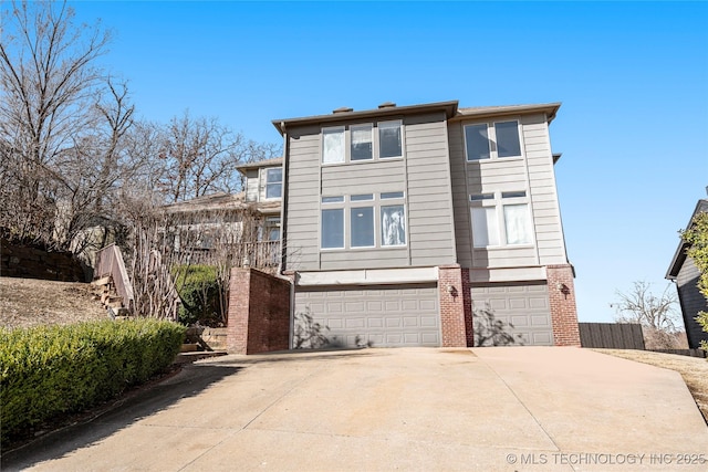 view of front of home featuring a garage, concrete driveway, and brick siding