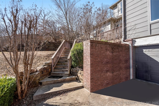 view of home's exterior featuring a garage and stairway