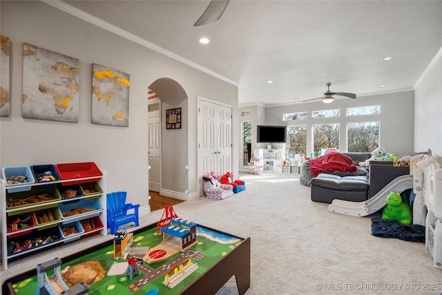 game room with arched walkways, a ceiling fan, ornamental molding, carpet floors, and recessed lighting