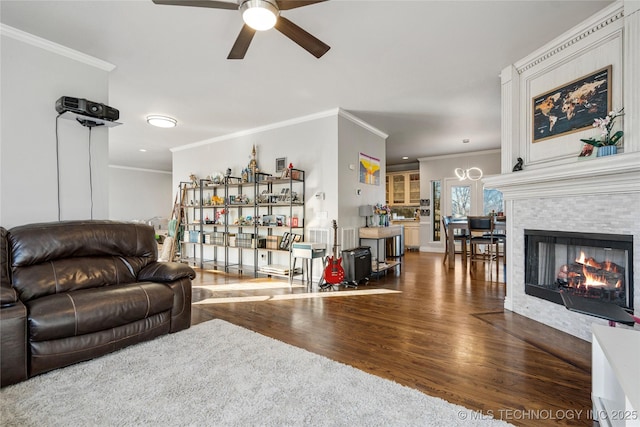 living room featuring ornamental molding, a tiled fireplace, and wood finished floors