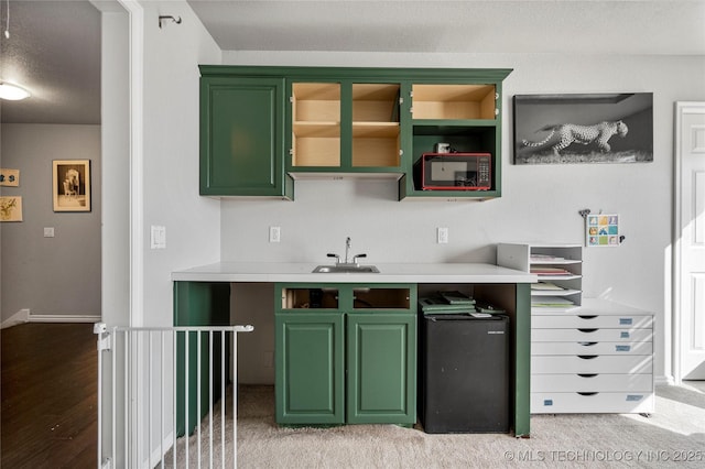 kitchen featuring a sink, a textured ceiling, light countertops, and green cabinetry