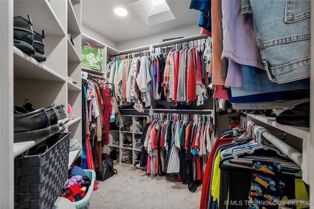 walk in closet with a skylight and carpet flooring