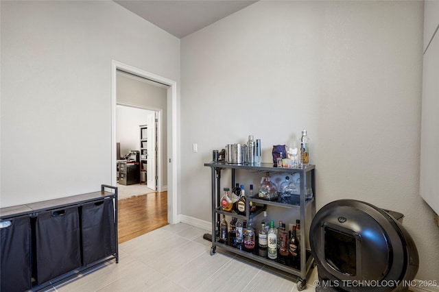 hallway featuring light tile patterned floors and baseboards