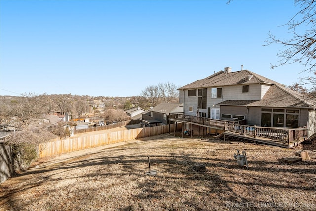 rear view of house featuring a fenced backyard and a deck