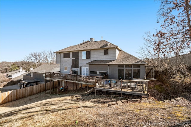 back of house featuring a fenced backyard, a deck, and roof with shingles