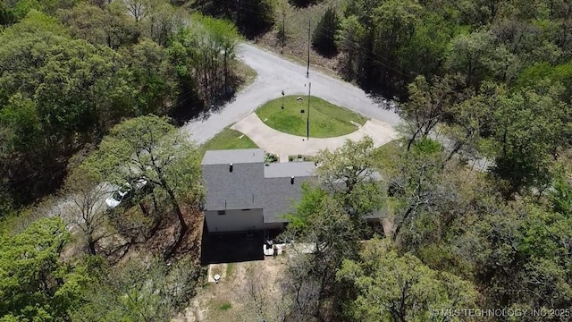 birds eye view of property featuring a forest view