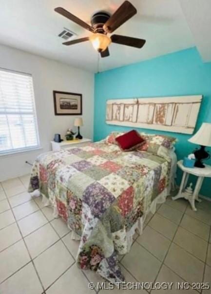 bedroom featuring tile patterned flooring, visible vents, and ceiling fan