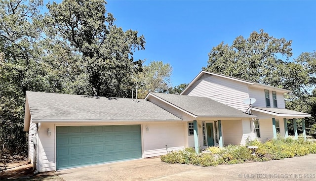 view of front of home featuring a garage, concrete driveway, and a shingled roof