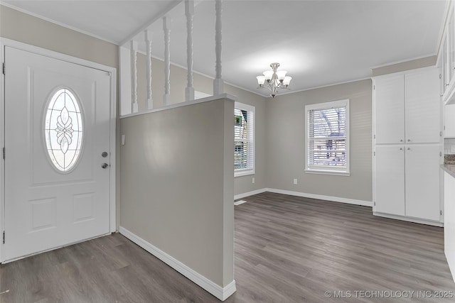 entrance foyer featuring baseboards, a chandelier, and wood finished floors