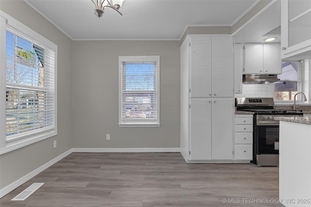 kitchen featuring visible vents, light wood-style floors, ornamental molding, under cabinet range hood, and stainless steel range with gas cooktop