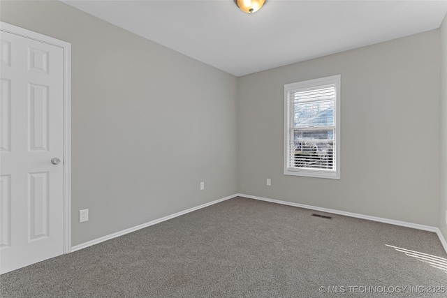 carpeted spare room with visible vents and baseboards