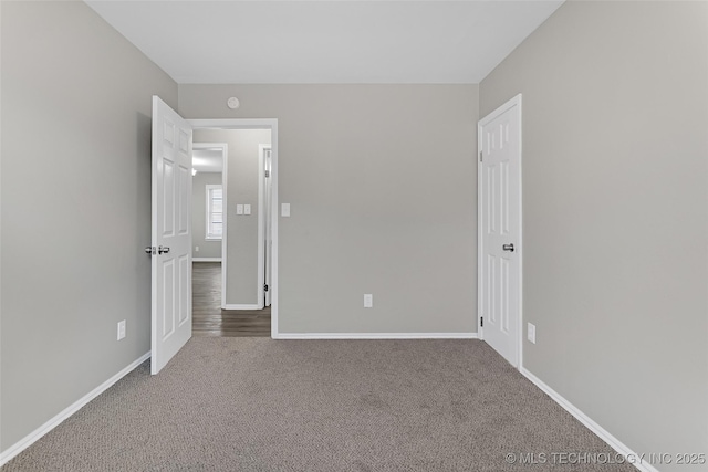 unfurnished bedroom featuring baseboards and carpet flooring