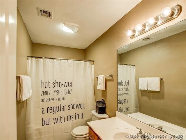 bathroom with toilet, curtained shower, visible vents, and vanity