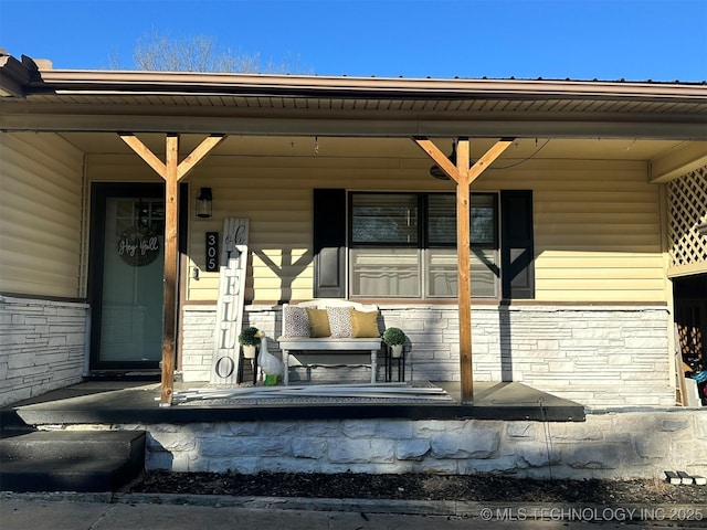 property entrance with covered porch and brick siding