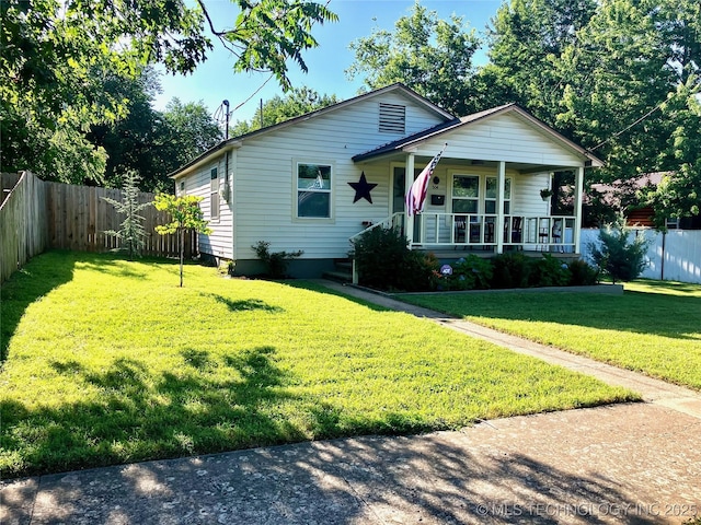 view of front facade featuring covered porch, a front yard, and a fenced backyard