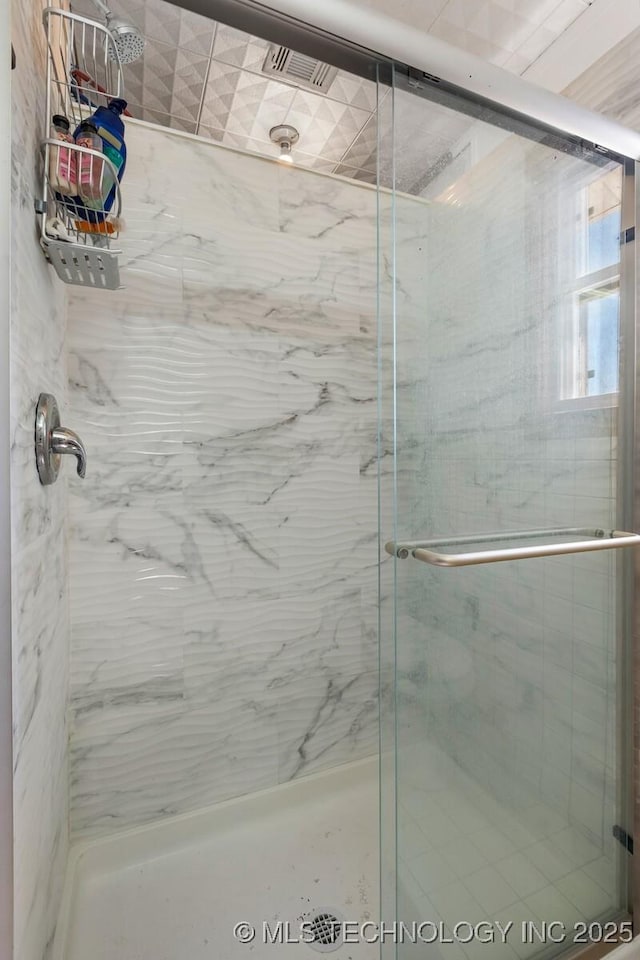 full bath featuring a marble finish shower and visible vents