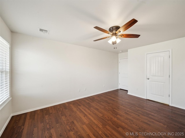 unfurnished bedroom with baseboards, visible vents, dark wood finished floors, and a ceiling fan