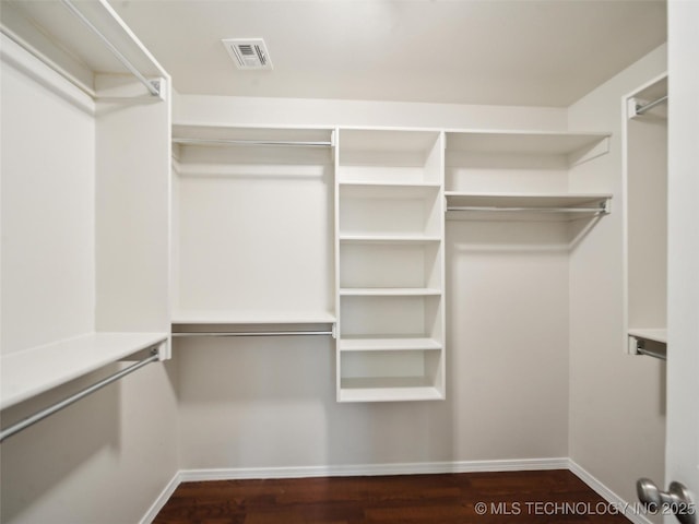 walk in closet featuring visible vents and dark wood-style flooring