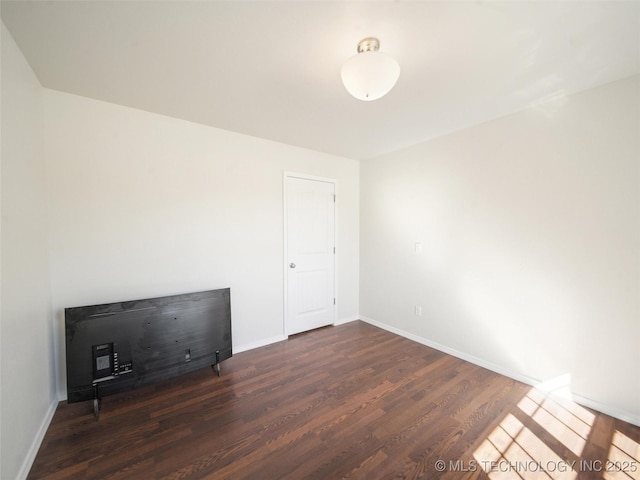 unfurnished room with baseboards and wood finished floors