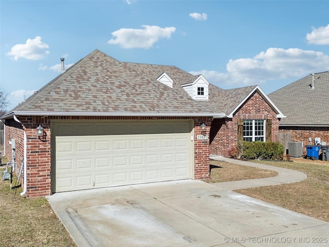 view of front of house with an attached garage, driveway, brick siding, and a shingled roof