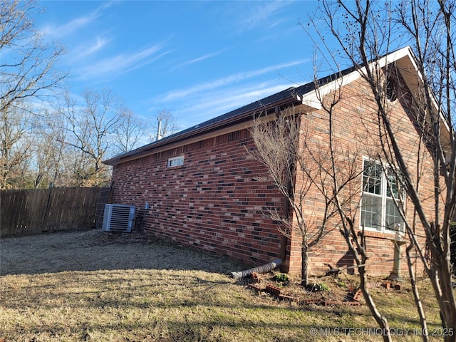 view of home's exterior featuring fence and brick siding