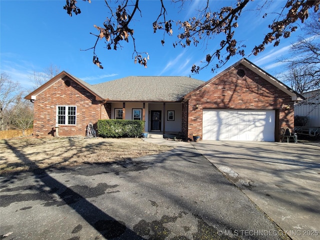 ranch-style house featuring a garage, driveway, brick siding, and roof with shingles