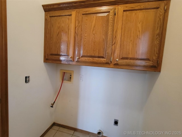 washroom featuring cabinet space, light tile patterned floors, baseboards, hookup for a washing machine, and electric dryer hookup