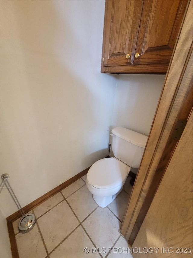 bathroom featuring tile patterned flooring, toilet, and baseboards