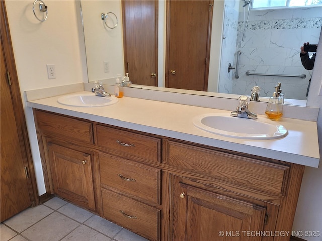 bathroom featuring double vanity, tile patterned flooring, walk in shower, and a sink