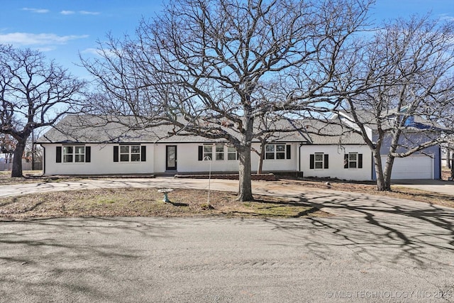 ranch-style home featuring driveway and stucco siding