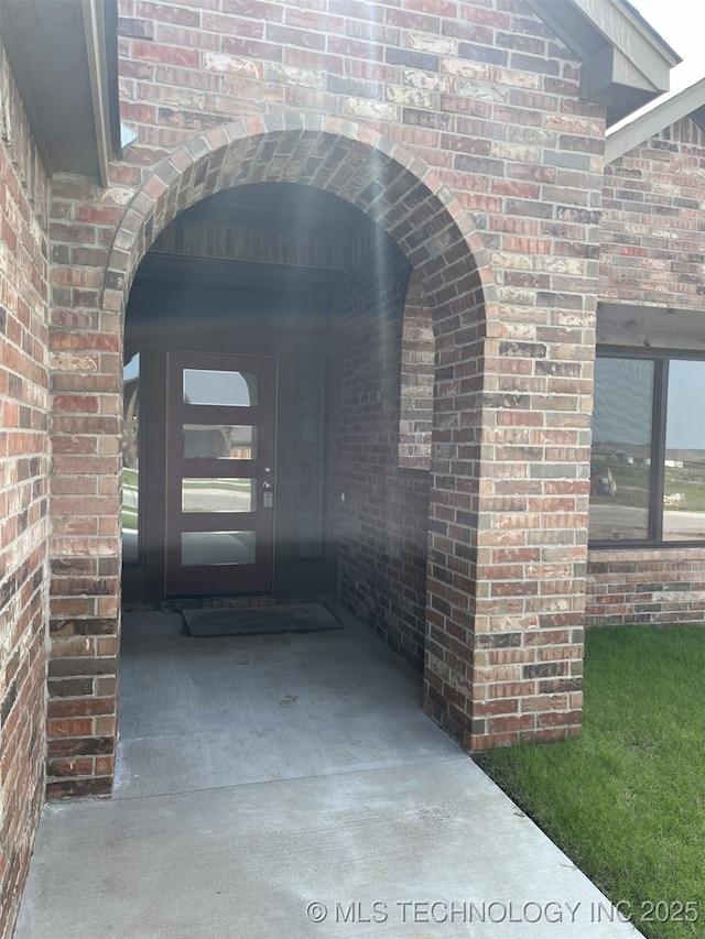 view of exterior entry with brick siding