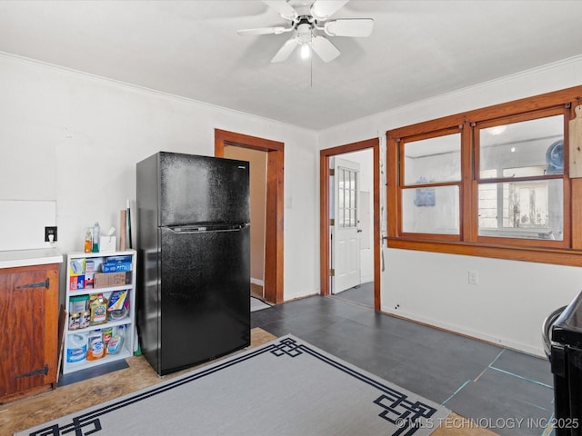 kitchen featuring a ceiling fan, light countertops, crown molding, and freestanding refrigerator