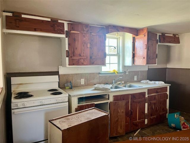 kitchen featuring white electric range oven, light countertops, and backsplash