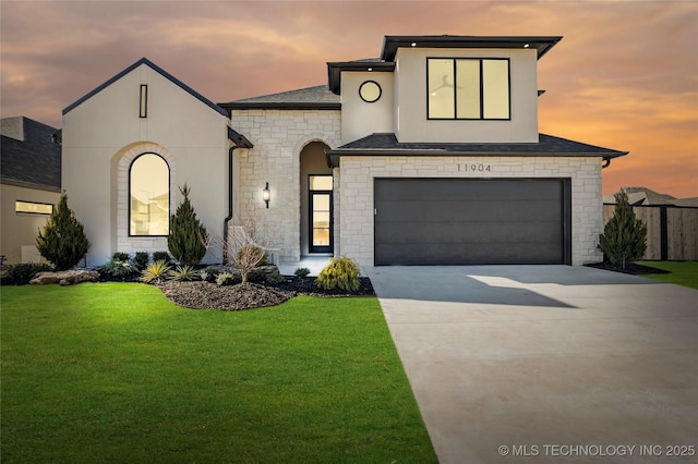 view of front facade with driveway, stucco siding, a garage, and a front yard