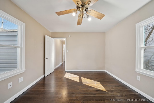 empty room featuring ceiling fan, baseboards, and wood finished floors