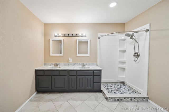 bathroom featuring a sink, a shower, and double vanity