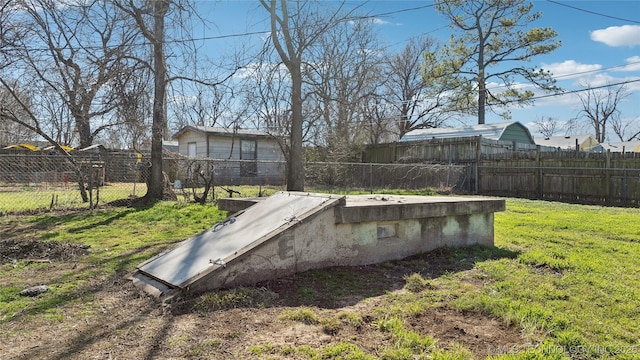 view of storm shelter featuring a lawn and fence