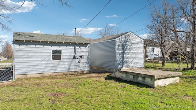 exterior space featuring a lawn, central AC, an outdoor structure, and fence